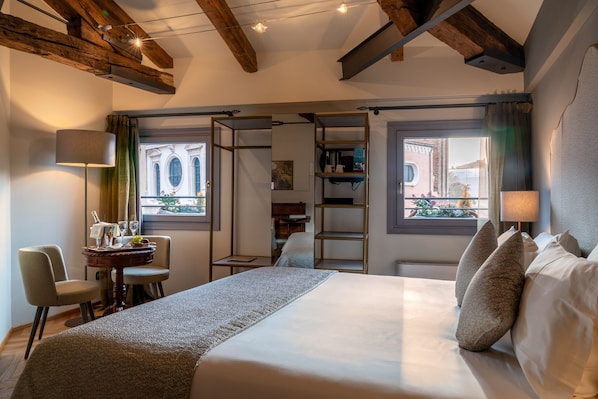 A hotel room with a large bed, a desk with a lamp, and a view of the outside. - EXCESS VENICE Boutique Hotel & Private Spa - Adults Only (Venice)