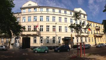 A large, historic building with multiple windows and a sign reading "Niederländischer Hof".