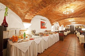 A long buffet table with various food items and a hanging plant.