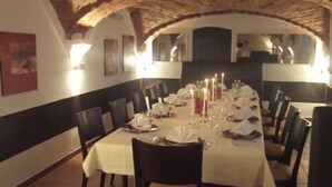 A restaurant with a long table set for a meal, featuring white tablecloths, candles, and neatly arranged plates and glasses. - Hotel Lehmeier (Neumarkt in der Oberpfalz)