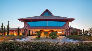 Un hotel moderno con un techo geométrico distintivo y amplias ventanas de vidrio.