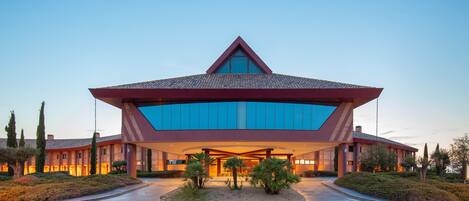 A modern hotel with a distinctive geometric roof and large glass windows.