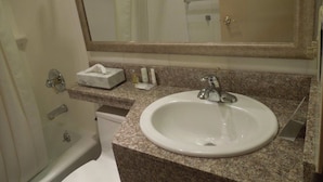 A bathroom with a sink, mirror, and toiletries.