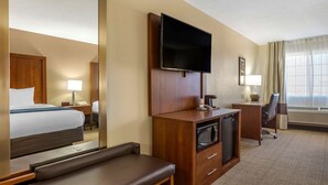 A hotel room with a bed, a desk with a flat-screen TV, a microwave, a lamp, and a window with curtains. - Comfort Inn & Suites Lordsburg I-10 (Lordsburg)