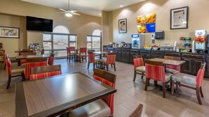 A spacious dining area with multiple tables and chairs, a kitchen area with a coffee machine, and a television mounted on the wall. - Comfort Inn & Suites Lordsburg I-10 (Lordsburg)