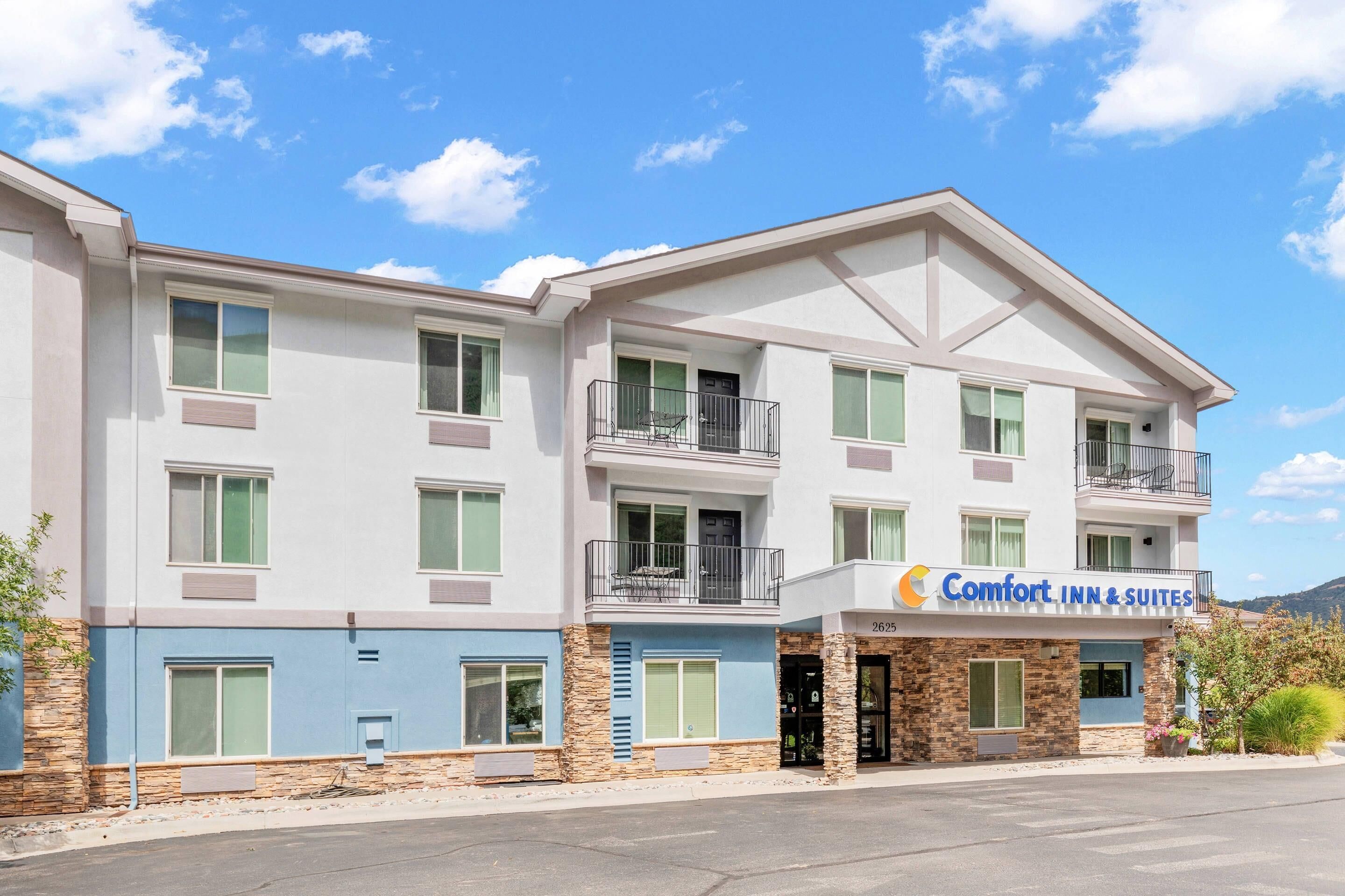 Ein mehrstöckiges Hotel mit der Aufschrift 'Comfort Inn & Suites', Balkonen und einer Stein-Fassade.