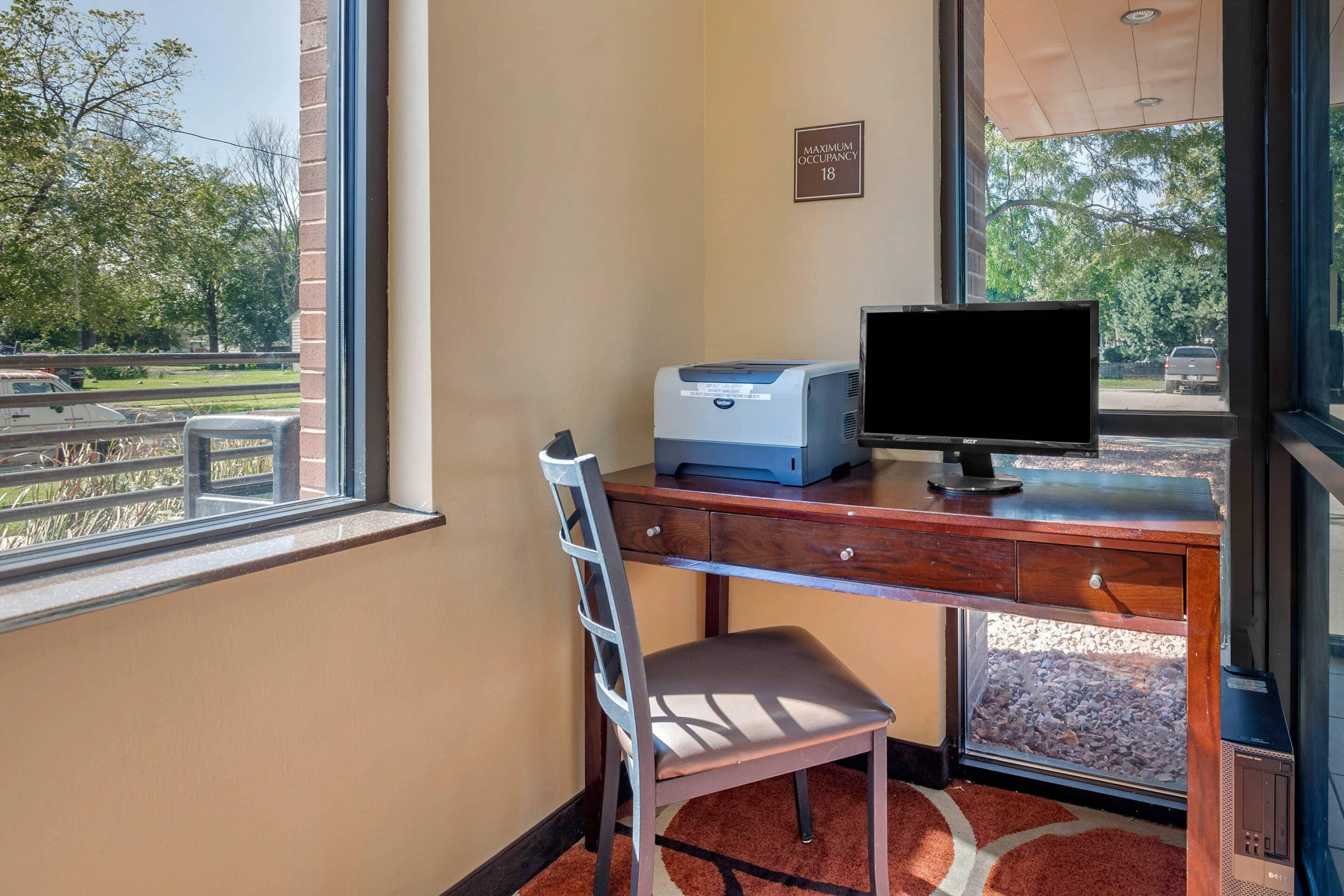 A room with a desk, chair, and a large window.