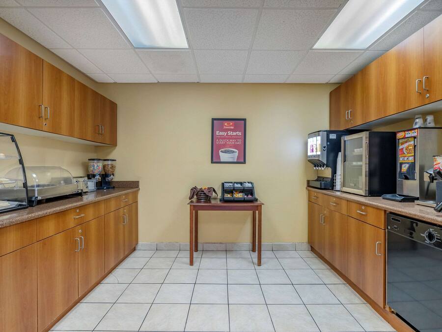 Una cocina con armarios de madera, una cafetera, un microondas y un refrigerador.