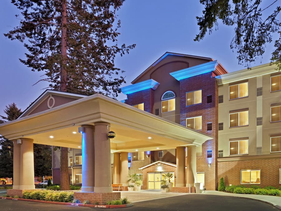 Un hotel con ingresso coperto, diverse finestre e facciata in mattoni.