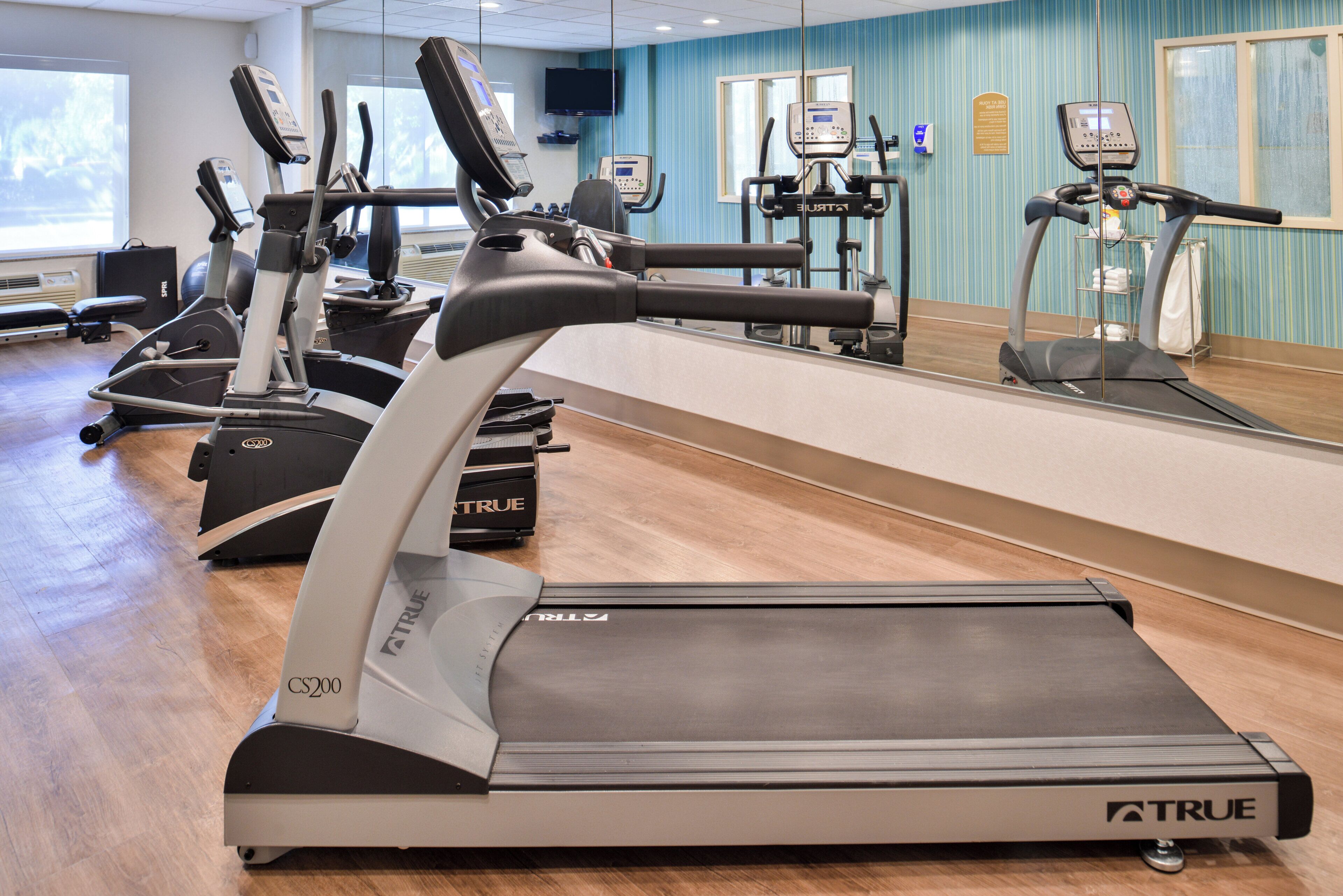 A gym with multiple treadmills, stationary bikes, and exercise equipment.