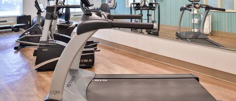 A gym with multiple treadmills, stationary bikes, and exercise equipment.