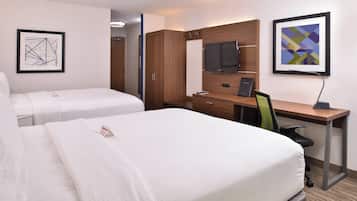A hotel room with two beds, a desk with a chair, a television, and artwork on the walls.