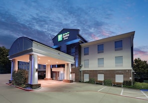 A Holiday Inn Express & Suites building with a covered entrance and a clear sky. - Holiday Inn Express Hotel & Suites Cleburne by IHG (Cleburne)