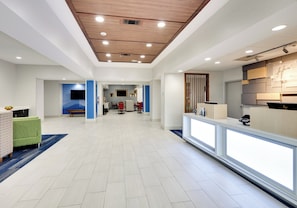 A spacious hotel lobby with a modern design, featuring a reception desk, seating area, and a large wall-mounted television. - Holiday Inn Express Hotel & Suites Cleburne by IHG (Cleburne)