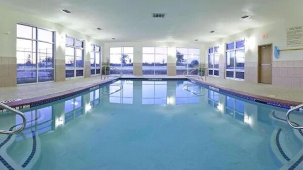 A large indoor swimming pool with clear blue water, surrounded by windows and a tiled wall. - Holiday Inn Express Hotel & Suites Cleburne by IHG (Cleburne)