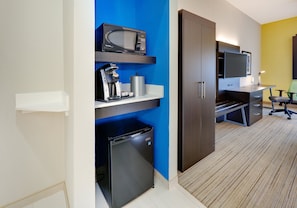 A compact hotel room with a kitchenette, a flat-screen TV, a desk, and a chair. - Holiday Inn Express Hotel & Suites Cleburne by IHG (Cleburne)