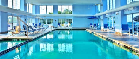 Una piscina techada, sillones reclinables de piscina