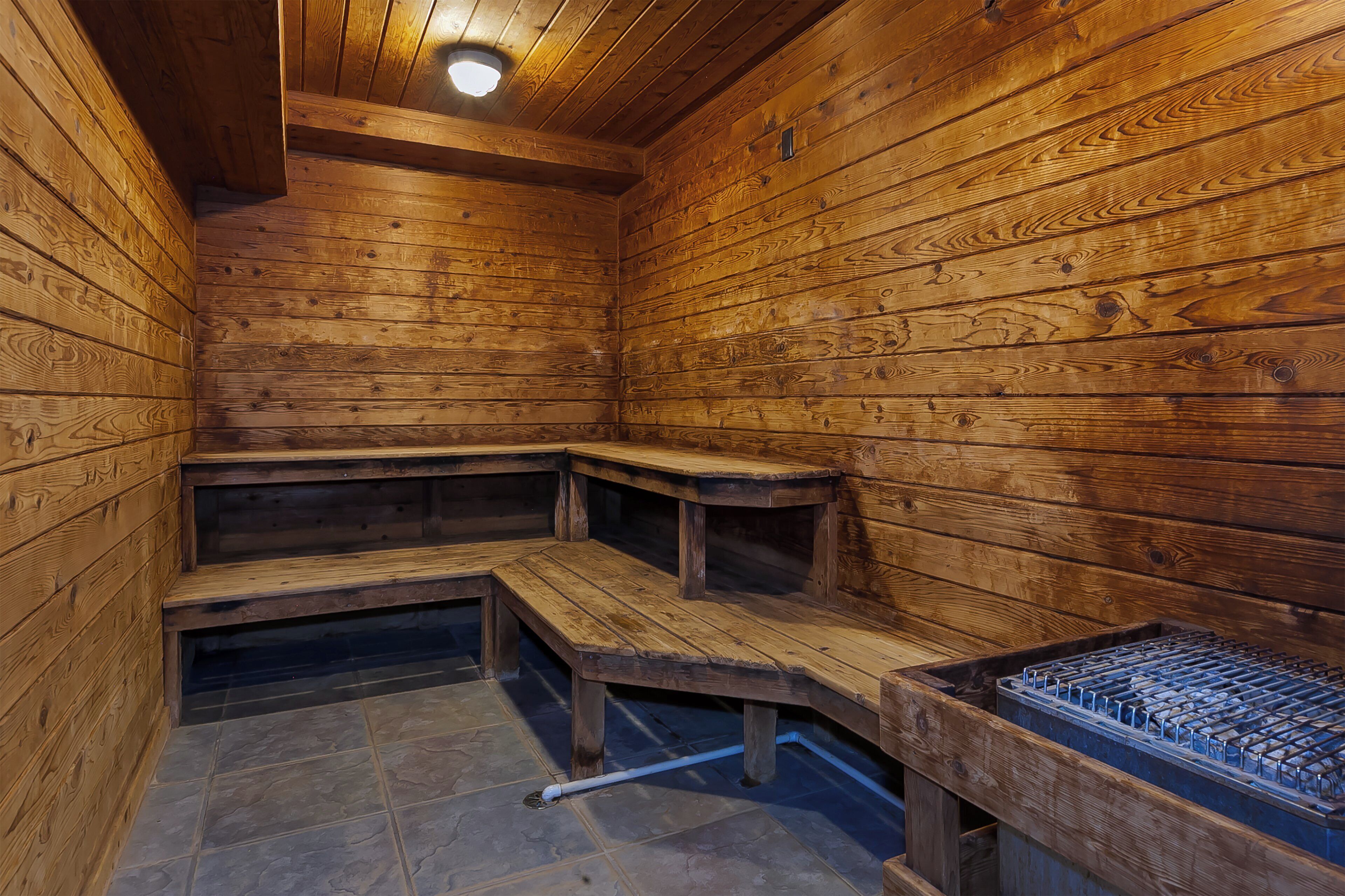 A sauna with wooden benches and a metal heating element.