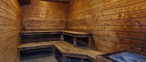 A sauna with wooden benches and a metal heating element.