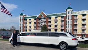 A white limousine parked in front of a multi-story hotel with balconies and a green roof. - Holiday Inn Express & Suites Petoskey by IHG (Petoskey)