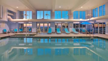 Relax by the pool surrounded by comfortable lounge chairs and shaded seating areas.