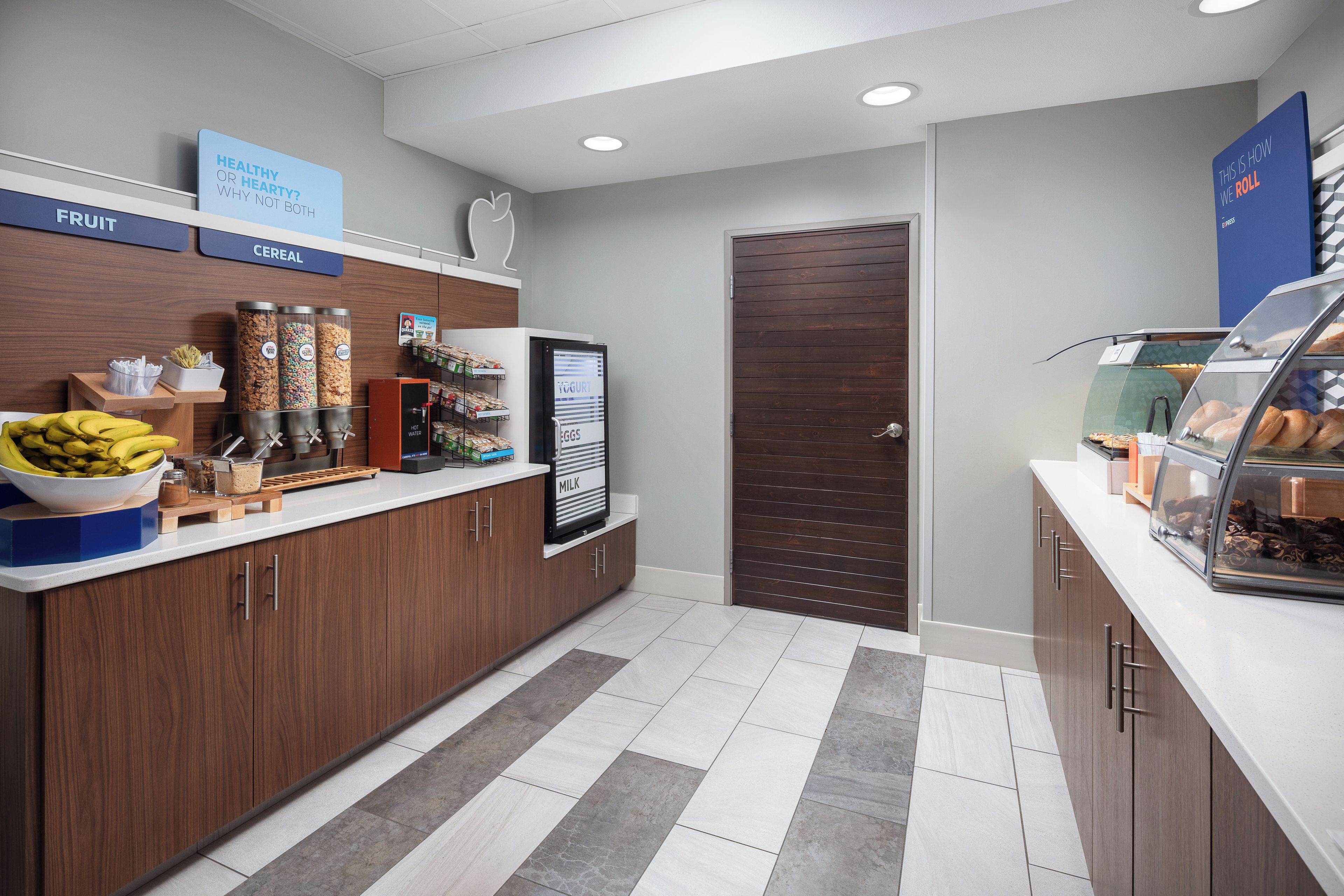 A self-service breakfast station with cereal, fruit, yogurt, eggs, and milk options.