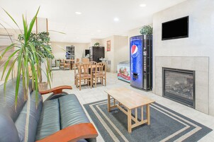 Una sala de estar moderna con sofá, sillones, una mesa de centro, chimenea y un televisor grande montado en la pared.