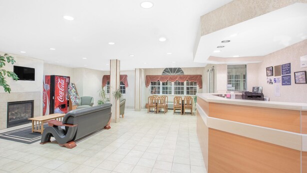 Eine moderne Lobby mit einer Rezeption, einer Sitzecke und einem Kamin.