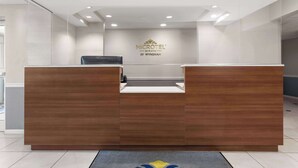 Un mostrador de recepción con el logotipo de 'MICROTEL INN & SUITES BY WYNDHAM' al fondo.