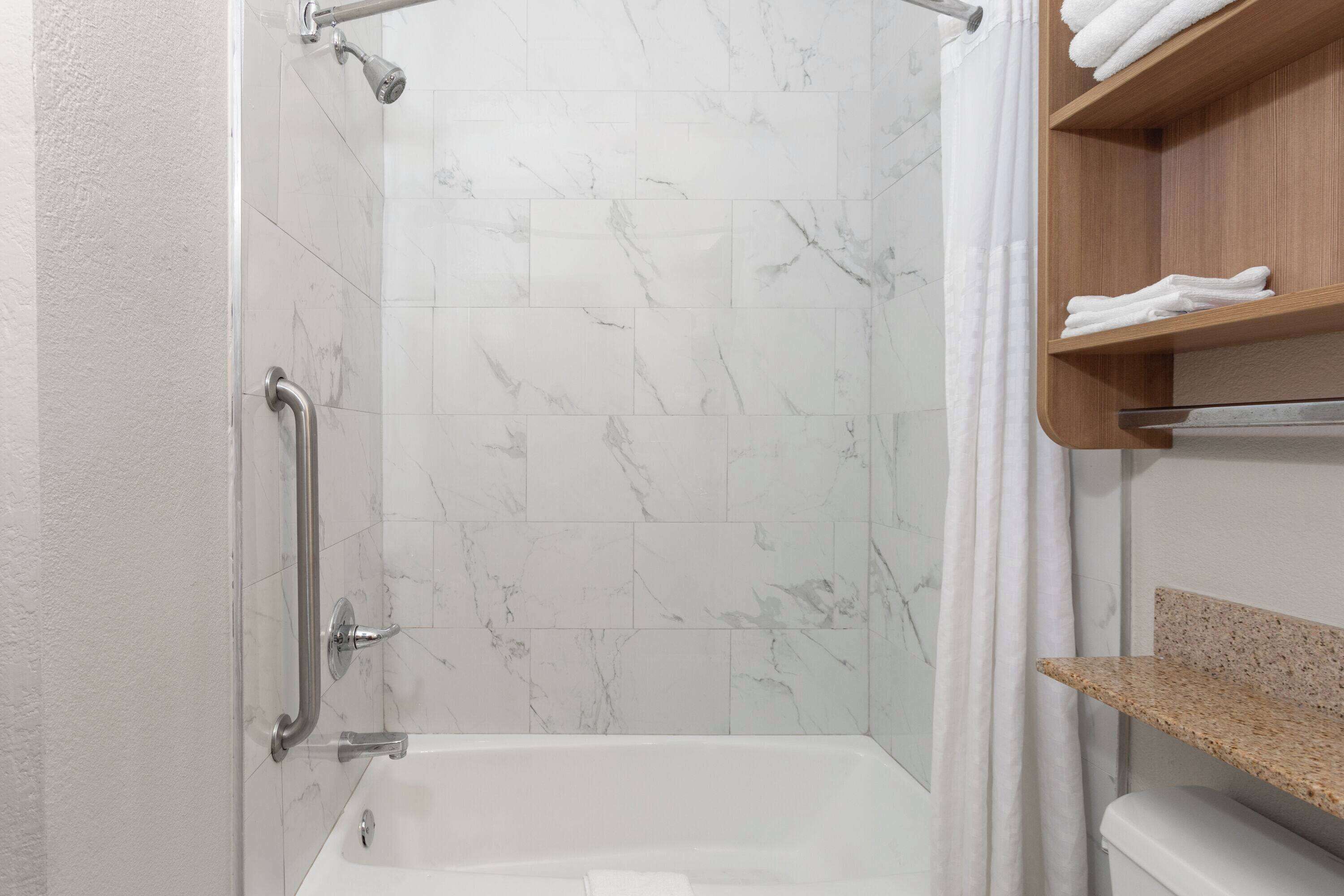 A bathroom with a shower, a bathtub, and a toilet.