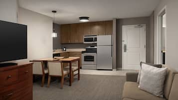 A compact living space with a kitchenette, a dining area, and a seating area.