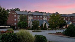 A multi-story hotel with a brick facade, multiple windows, and a parking lot. - Residence Inn by Marriott Greensboro Airport (Greensboro)