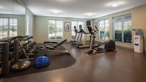 A gym with treadmills, elliptical machines, free weights, and a blue medicine ball. - Staybridge Suites Fairfield Napa Valley Area by IHG (Fairfield)