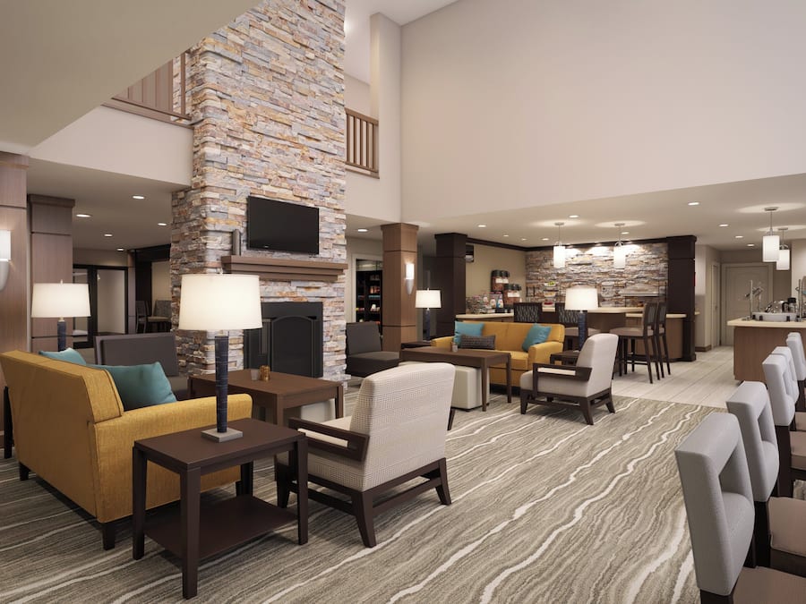 A spacious lobby with a stone accent wall, seating areas, and a bar.
