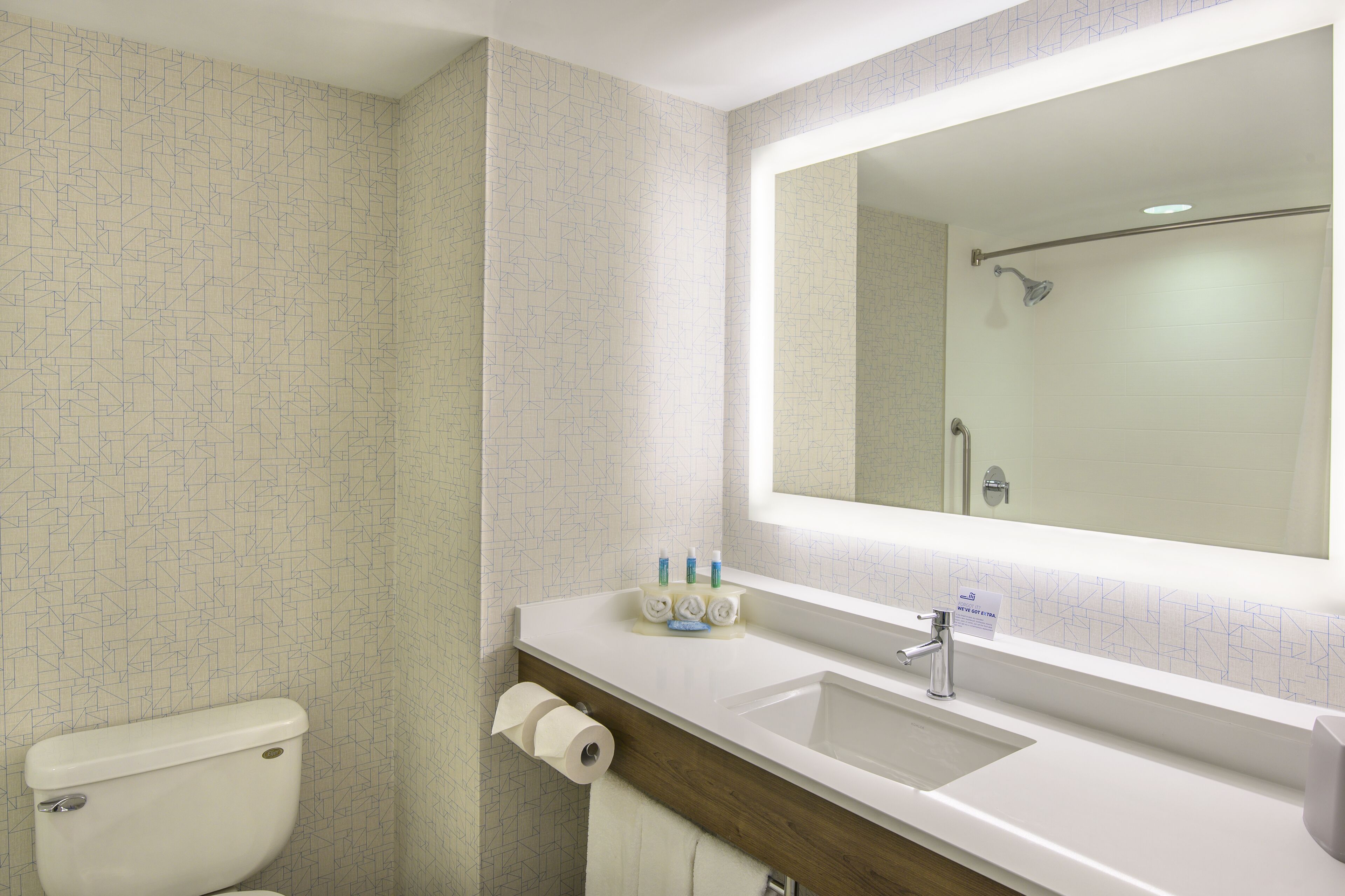 Un baño con inodoro, lavabo y espejo.