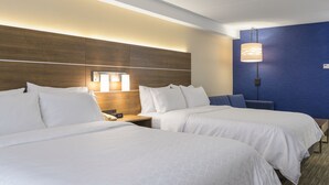 A hotel room with two beds, a wooden headboard, a nightstand with a lamp, and a blue accent wall. - Holiday Inn Express & Suites North Bay by IHG (North Bay)