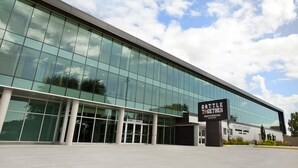 A modern building with large glass windows and a sign reading "BATTLE TOGETHER". - Holiday Inn Express & Suites North Bay by IHG (North Bay)
