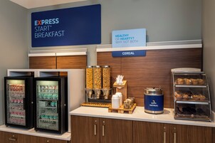 A breakfast station with a sign reading 'EXPRESS START BREAKFAST' and a sign asking 'HEALTHY OR HEARTY? WHY NOT BOTH'. There are cereal dispensers, a yogurt fridge, and a Quaker Oatmeal dispenser.