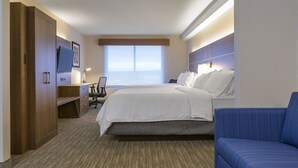 A hotel room with a bed, a desk, a chair, a TV, and a sofa. - Holiday Inn Express & Suites North Bay by IHG (North Bay)