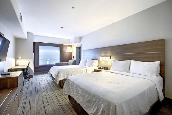 A hotel room with two beds, a desk, a chair, a TV, and a window with a view. - Holiday Inn Express Airport-Calgary by IHG (Calgary)