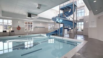 Una piscina interior con un tobogán azul y otro tobogán de agua.