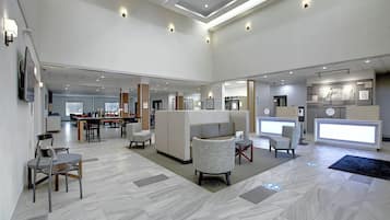 A spacious lobby with a reception desk, seating area, and a dining section.