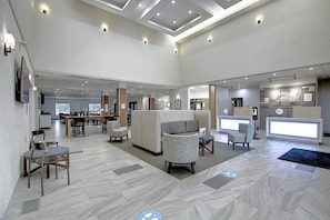 A spacious lobby with a reception desk, seating area, and a dining section. - Holiday Inn Express Airport-Calgary by IHG (Calgary)