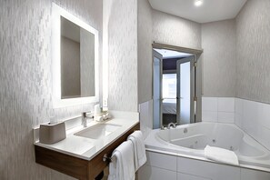 A modern bathroom with a large mirror, two sinks, a bathtub, and a wooden vanity. - Holiday Inn Express Airport-Calgary by IHG (Calgary)