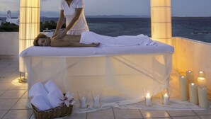 A massage therapy session on a terrace with a view of the sea, candles, and a basket of towels. - Oasis Beach Hotel (Agistri)
