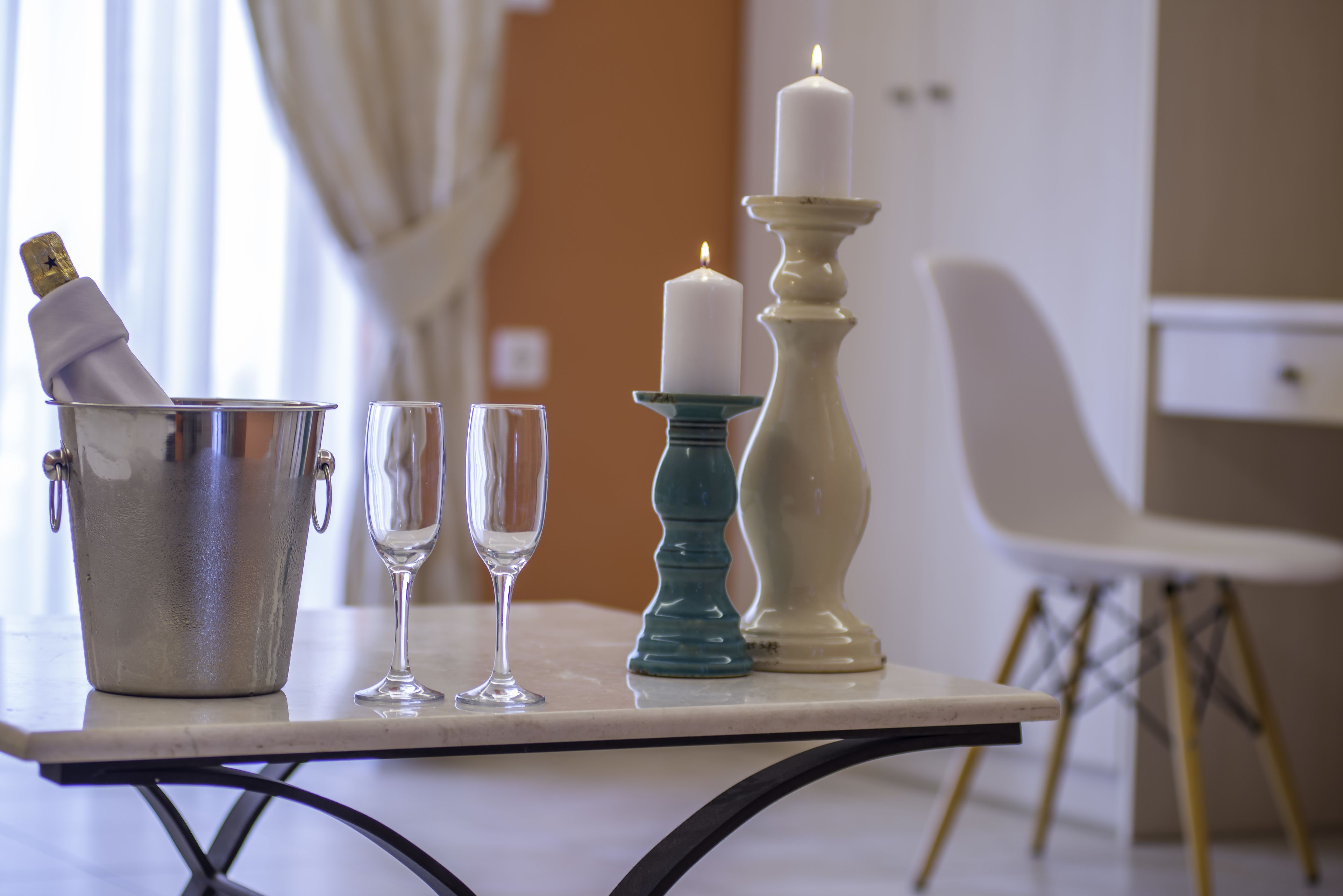 Una mesa con una botella de champán, dos copas y dos velas.