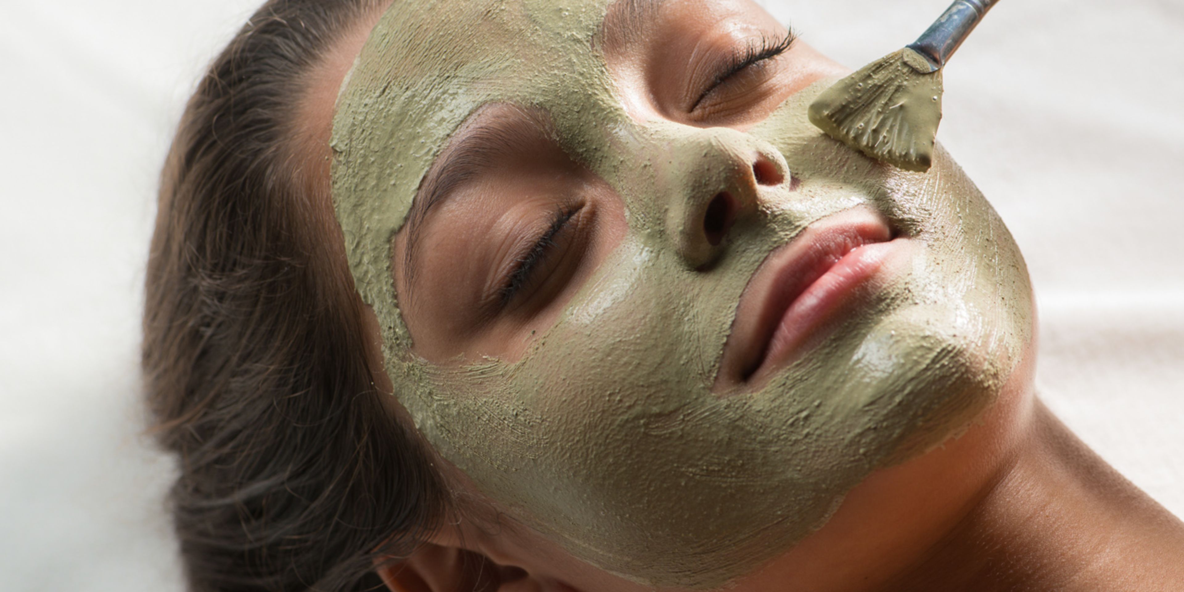 A person with a green facial mask.