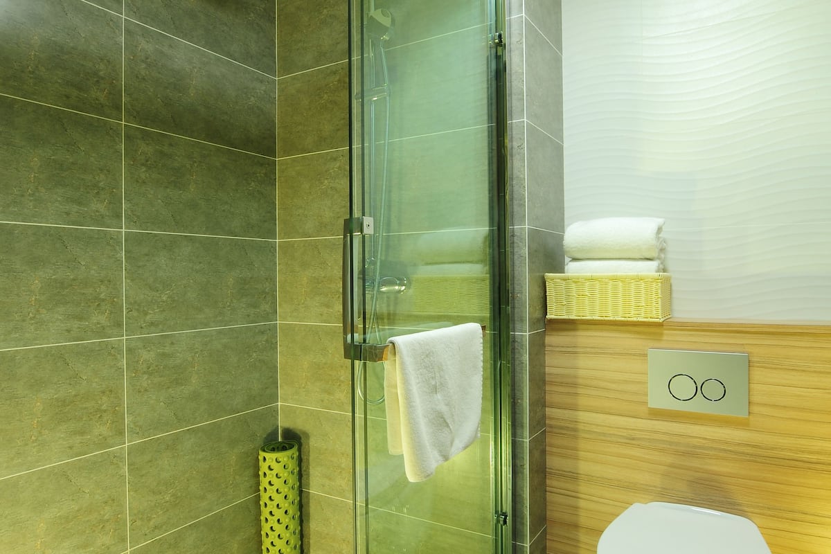 separate bathtub and shower, rainfall showerhead, slippers, towels
