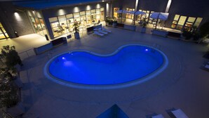 Piscina con sillas de descanso y zona de restaurante.