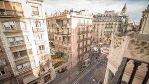 A multi-story building with balconies, a street in front, and a clear view of the sky. - Petit Palace Museum (Barcelona)